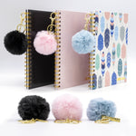 Collection of black, pink and blue keyrings attached to coordinating hardcover notebooks.